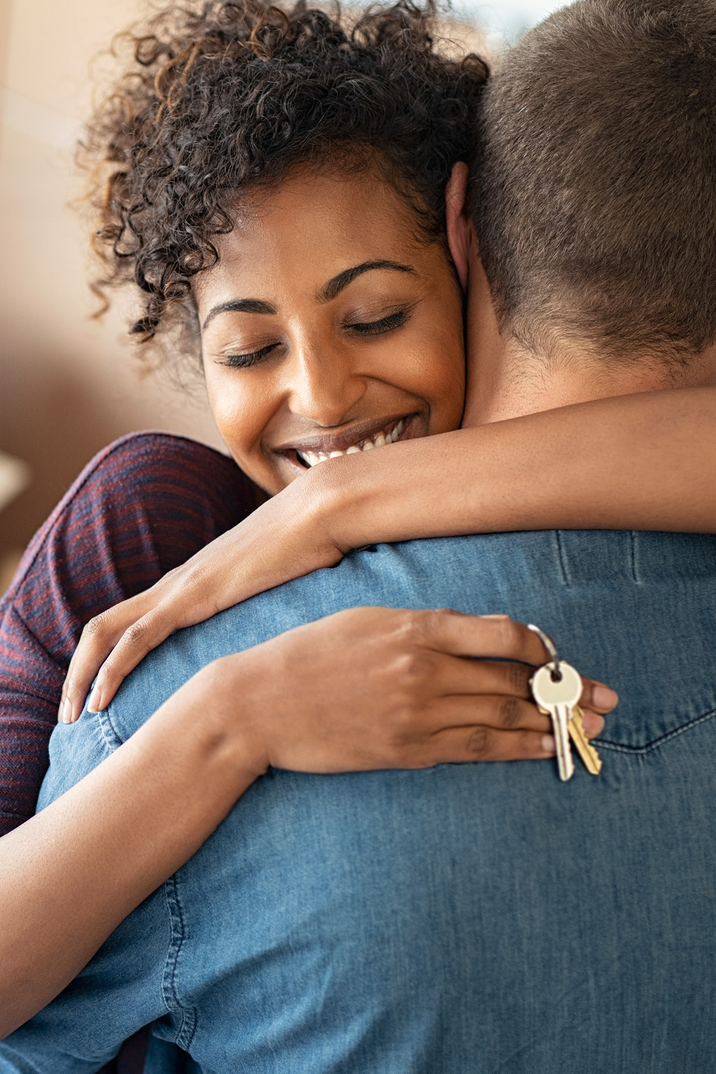 couple hugging while woman holds keys