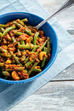 green bean and tomato curry in blue bowl