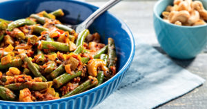 green bean and tomato curry in blue bowl