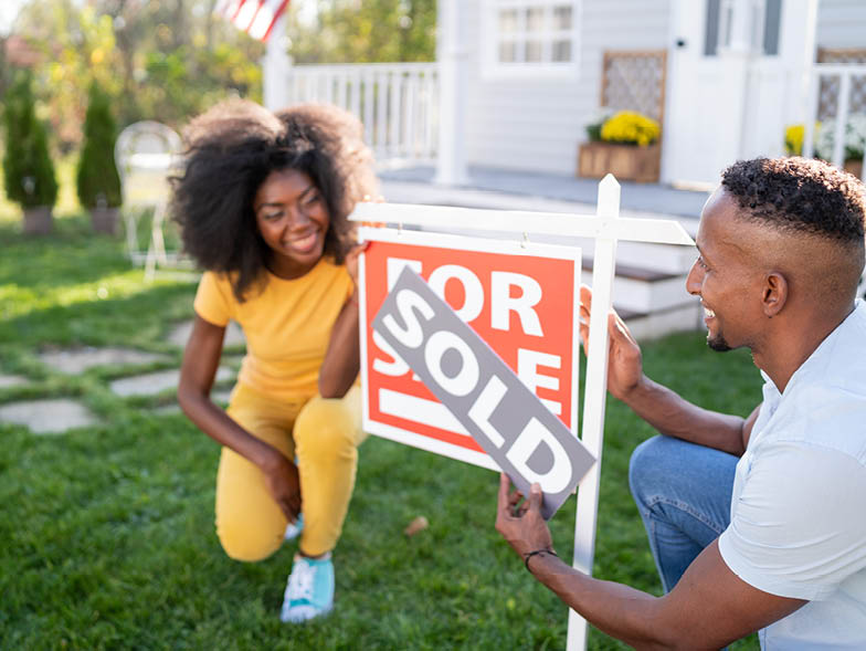 woman and man holding for sale sign