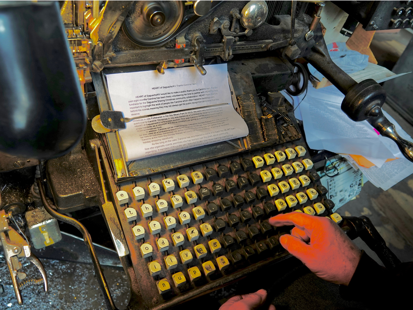 Man typing on linotype machine