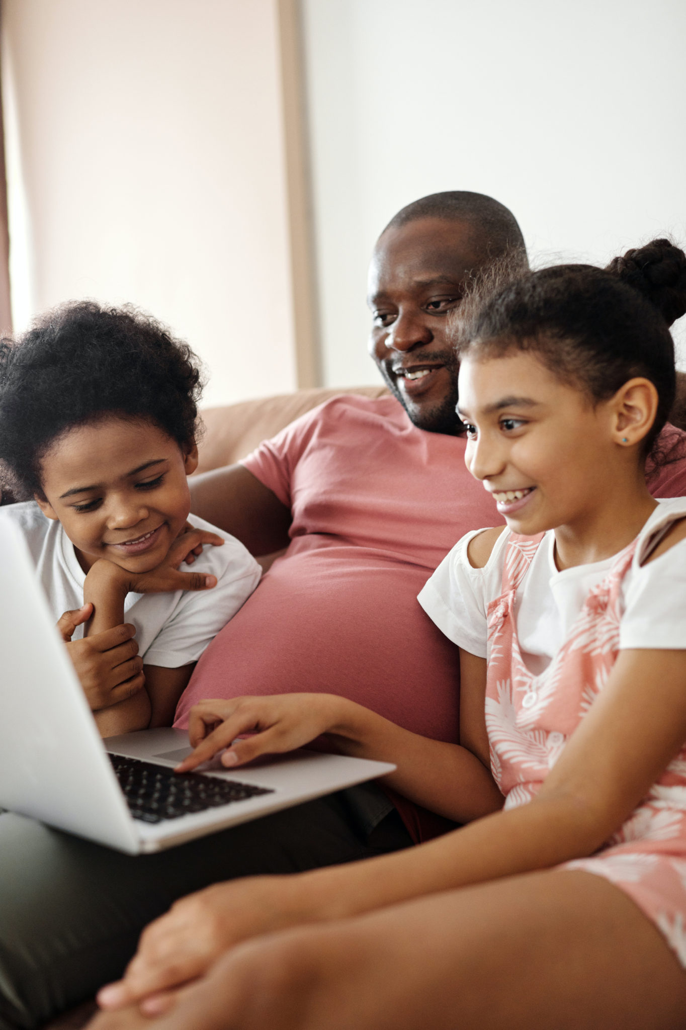 father and daughters on laptop