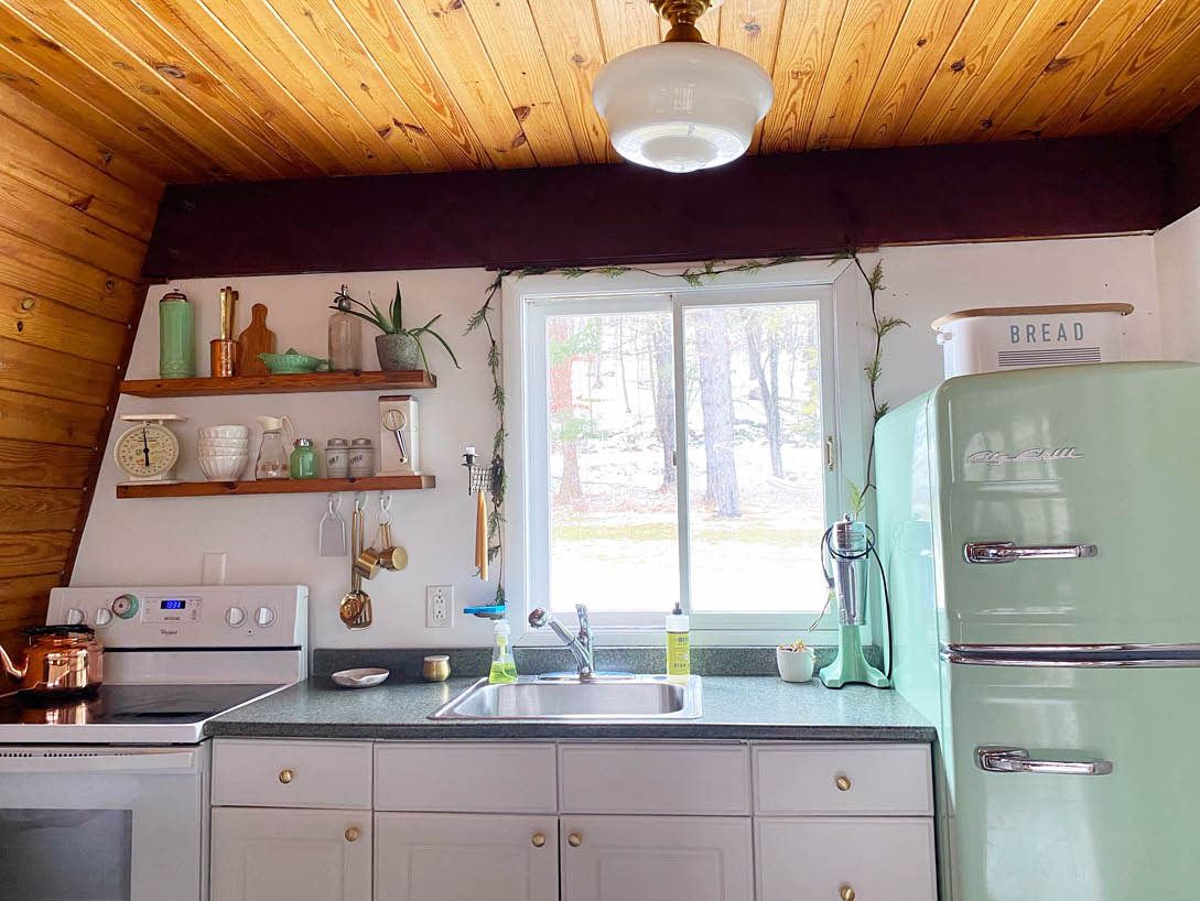 cabin kitchen with white cabinets and wood ceiling