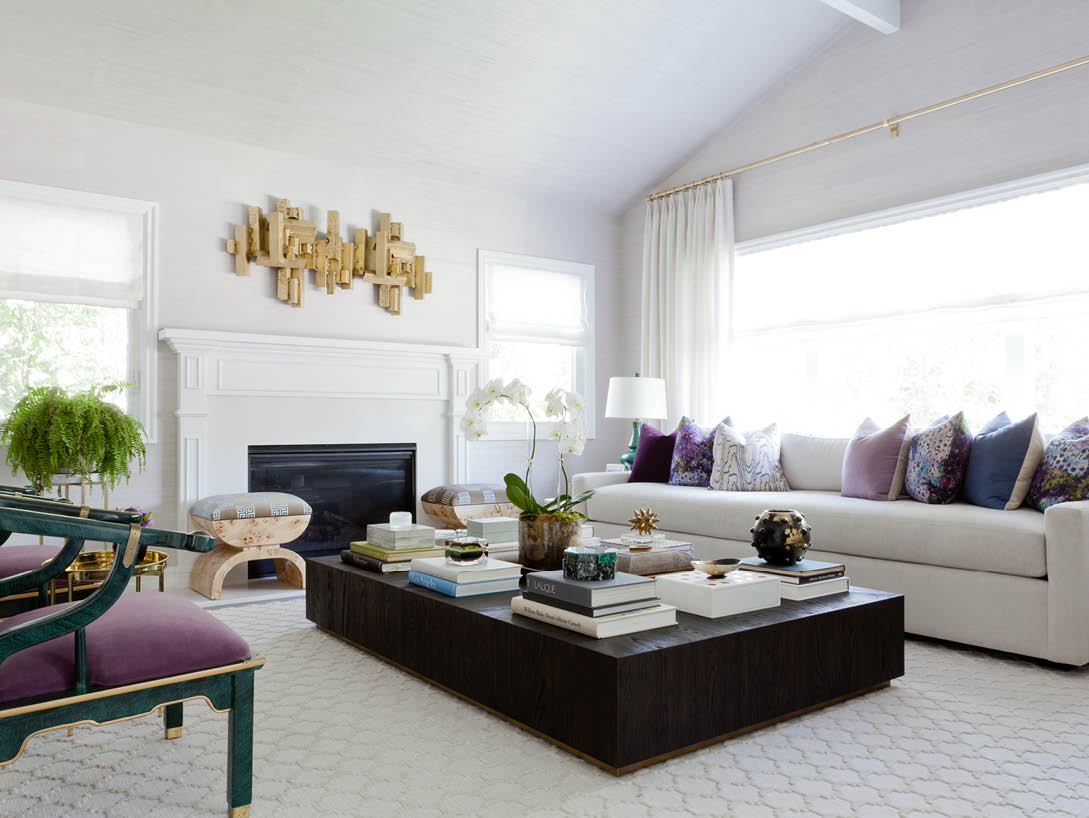 living room with white furniture and purple and blue pillows