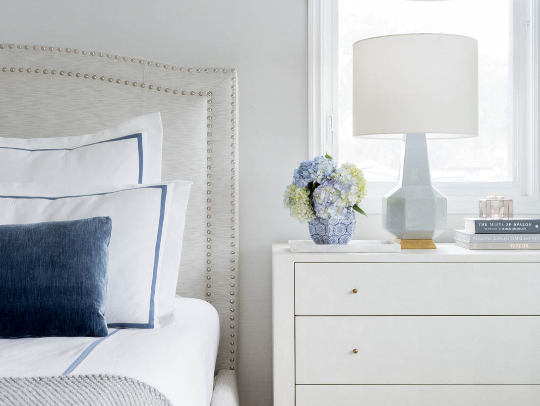 bedroom with white and blue comforter and white dresser
