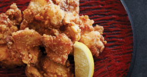 japanese fried chicken on red plate with lemon wedge