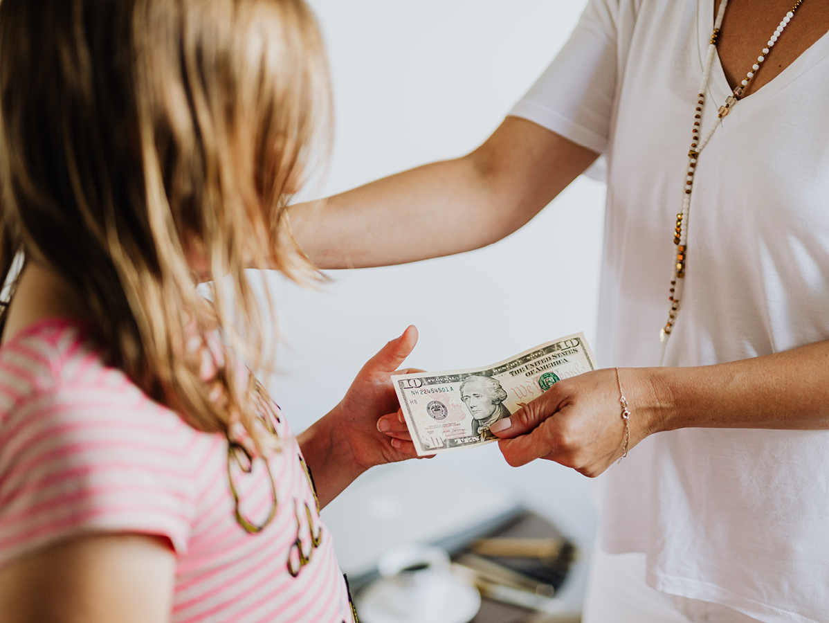 person handing a child money