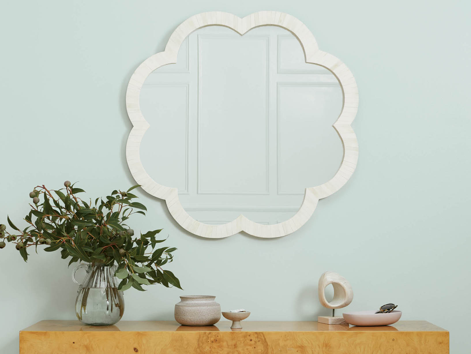light blue wall with white mirror