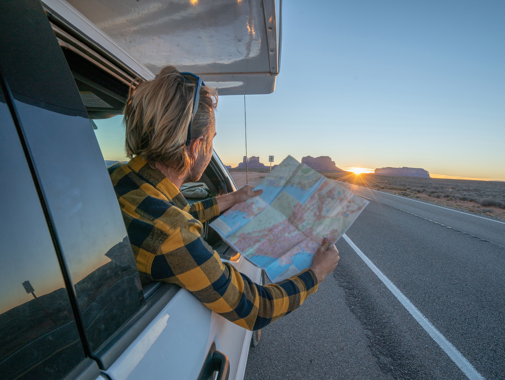person using paper map on the road