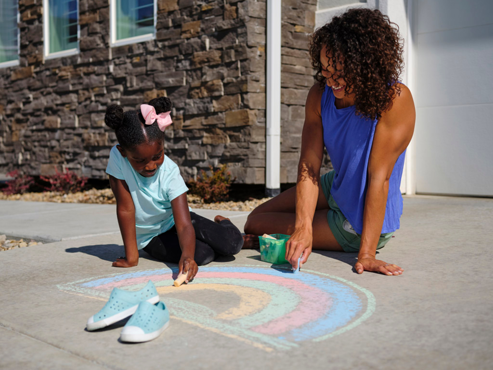 parent and child using sidewalk chalk