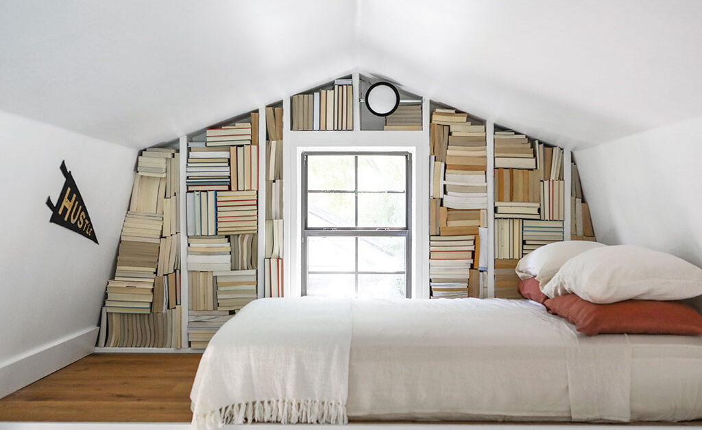 Loft bedroom with wall full of books
