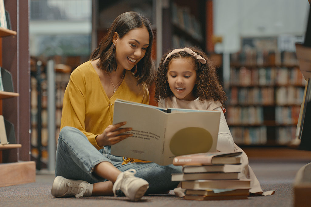 Entertainmment news Mom and daughter reading book in library