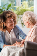 Woman talking with older woman in rocking chair