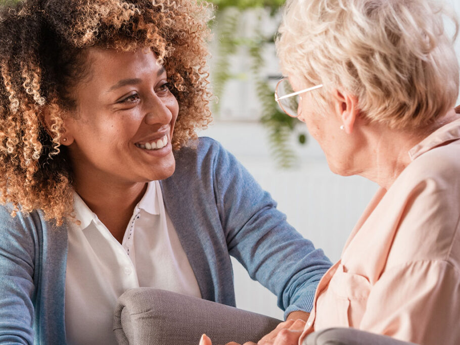 Woman talking with older woman in rocking chair