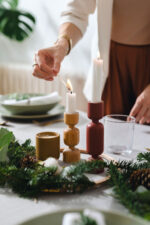 Woman hosting dinner and lighting candle