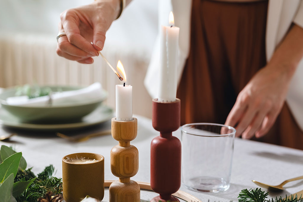 Woman hosting dinner and lighting candle